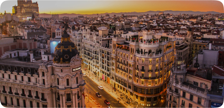 Imagem com uma vista panorâmica de cima sobre a cidade de Barcelona, apresentado seus prédios que formam quadrados com seus pátios no meio da estrutura, envoltos de fachadas clássicas e elegantes.